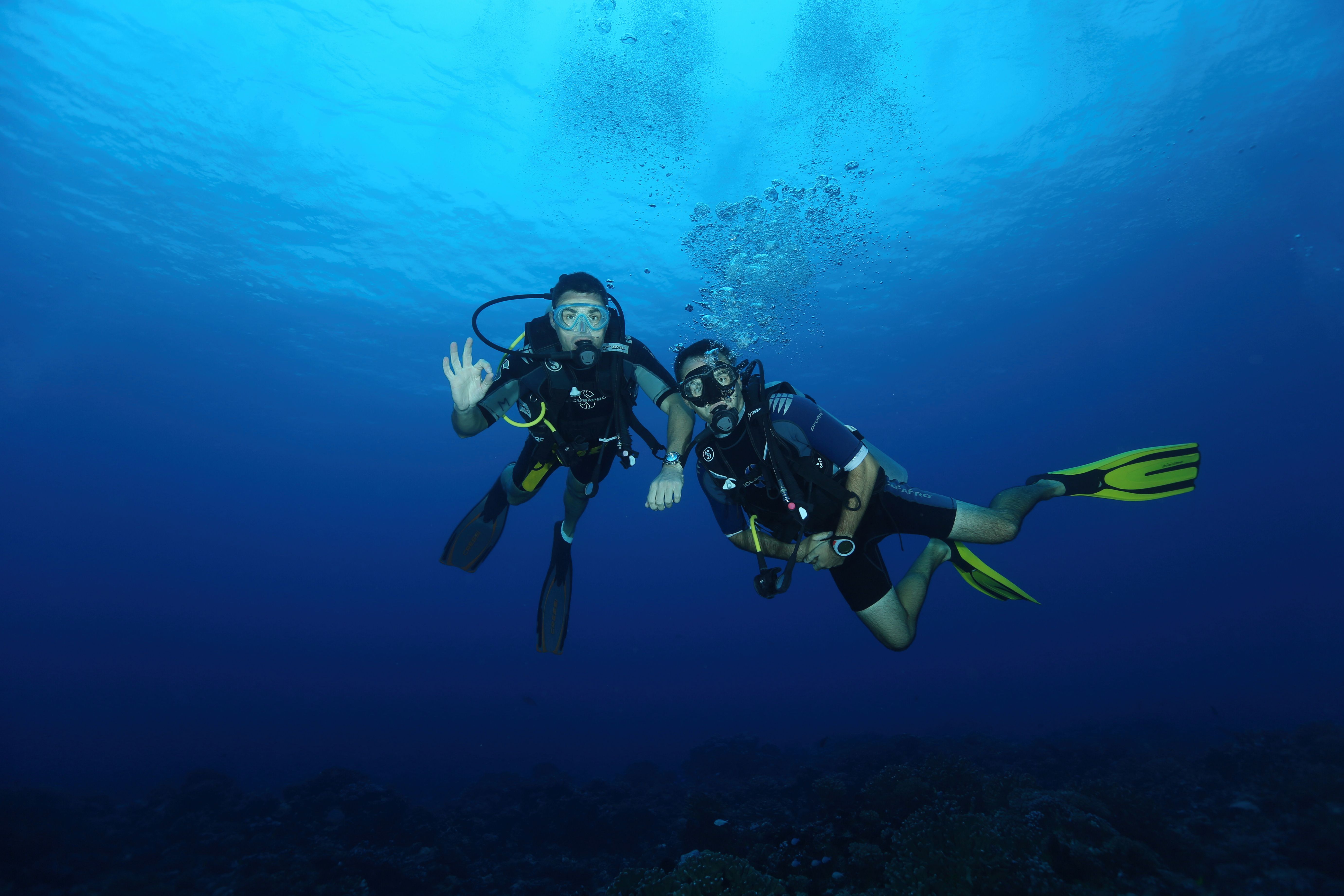 Divers signalling OK over Chumphon Pinnacle, Koh Tao