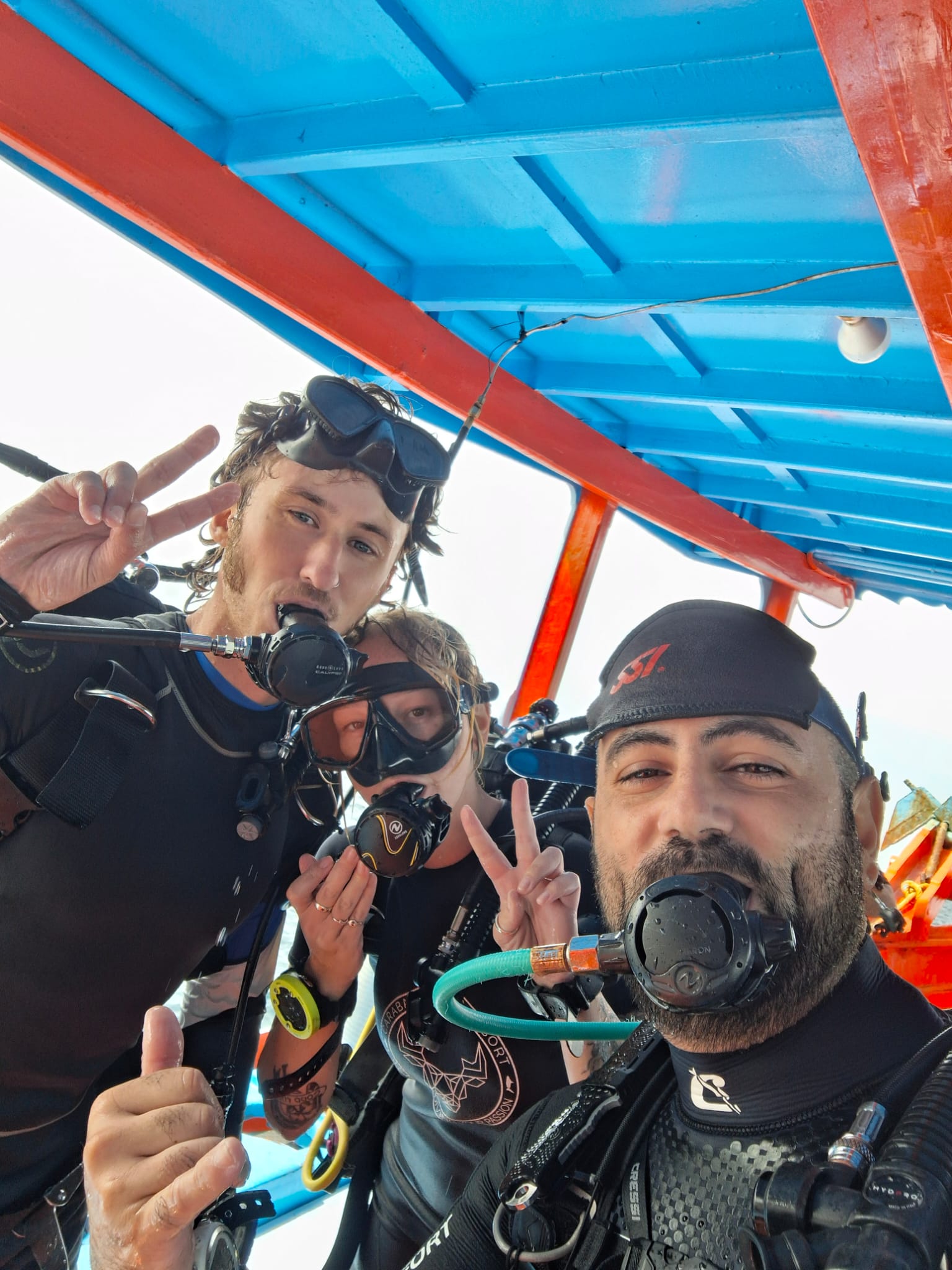 Divers joking around with their regulators on the Carabao dive boat
