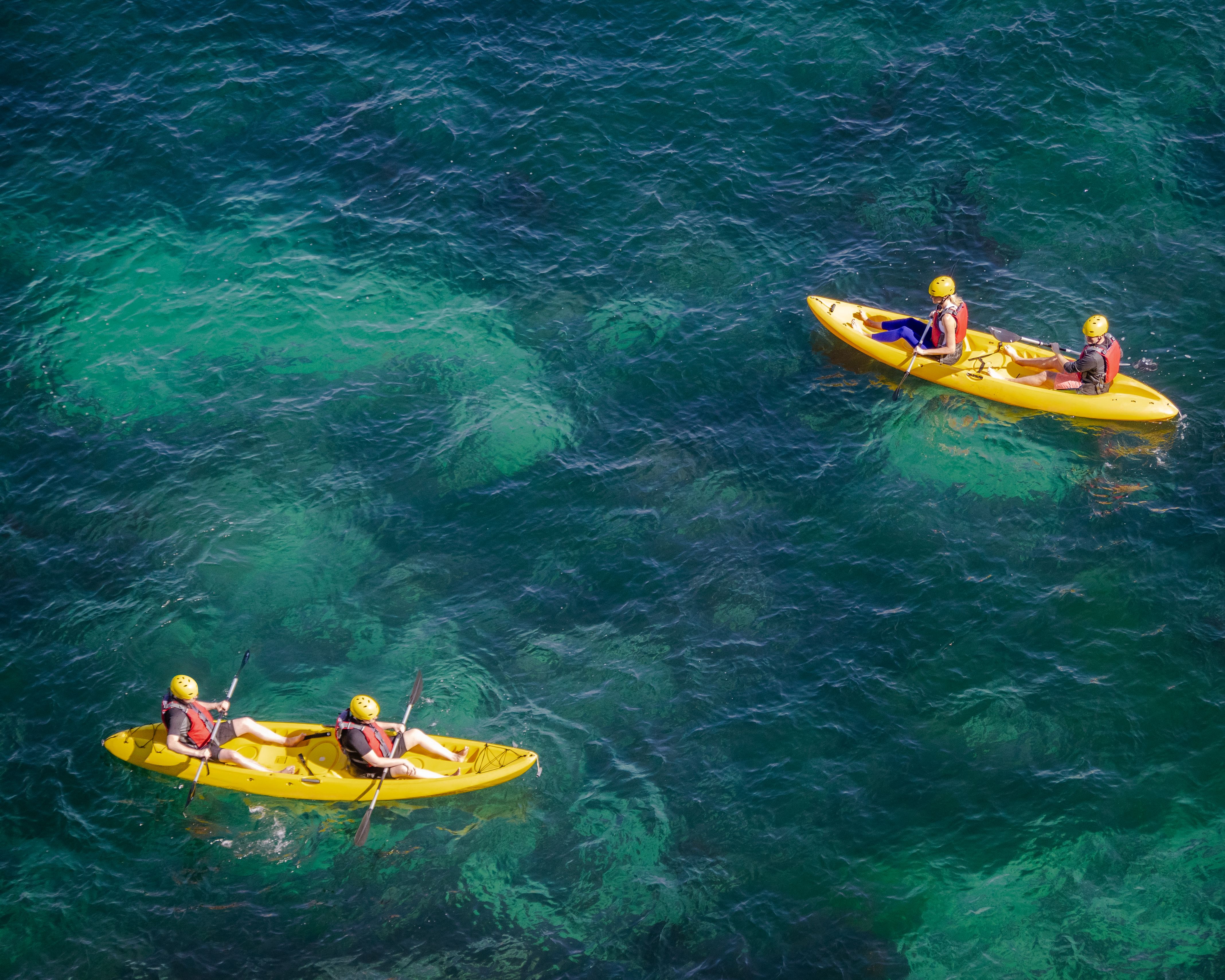 Guests paddling free kayaks over clear water at Koh Tao