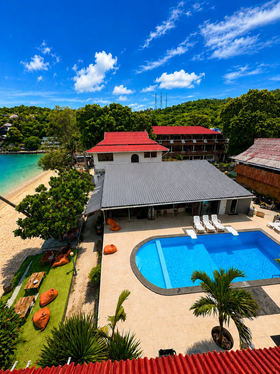 Aerial of Carabao Diving Resort showing the beachfront pool, restaurant and rooms on Chalok Bay, Koh Tao