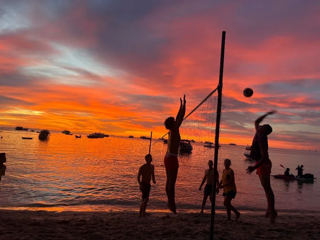 Beach volleyball silhouetted against a fiery sunset over Chalok Bay at Carabao Diving Resort, Koh Tao